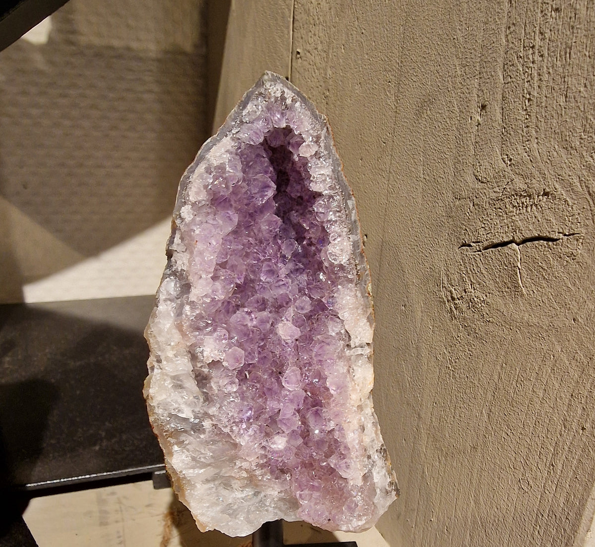 Amethist geode op een zwarte metalen voet