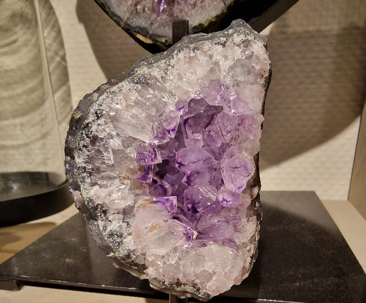Amethist geode met grote kristallen op een zwarte metalen voet