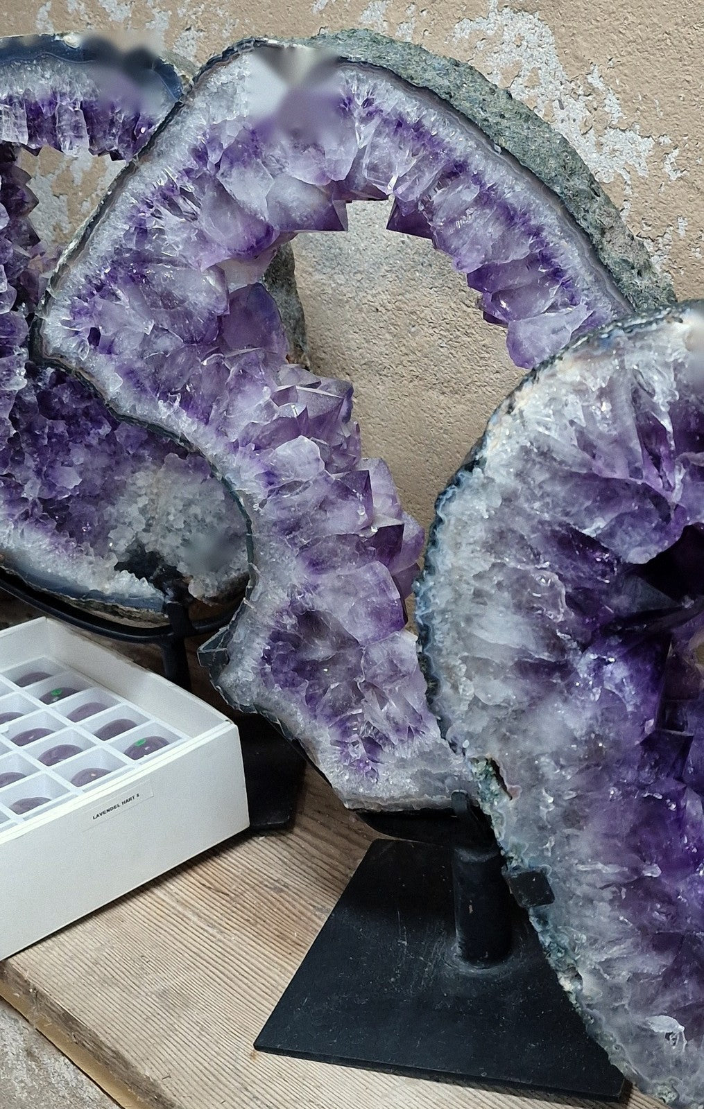Amethist ringplaat met grote opening en kristalrand op een zwarte standaard